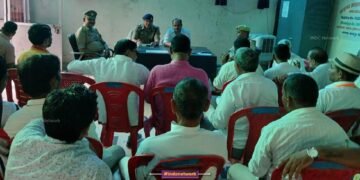 पुलिसकर्मी आयोजकों से बात करते हुए